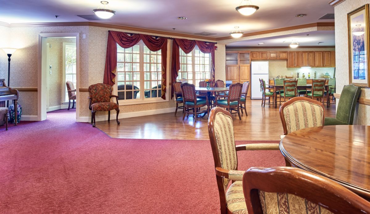 A spacious dining and kitchen area featuring elegant furniture, hardwood floors, and warm lighting.