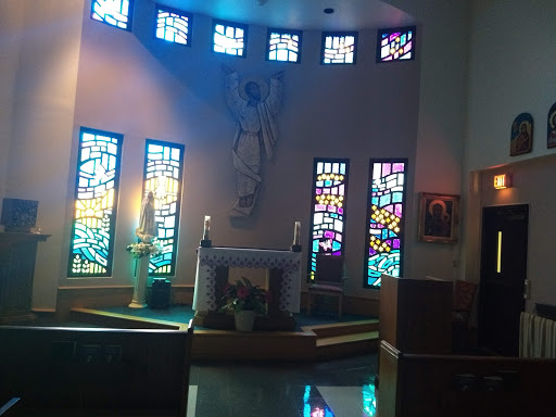 Interior view of a church featuring beautiful stained glass windows and an altar.