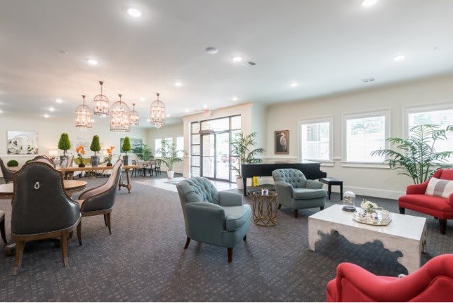 A modern, well-lit lounge area featuring comfortable seating and elegant chandeliers.