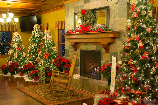 A beautifully decorated room for Christmas featuring a warm fireplace, festive trees, and vibrant holiday decorations.