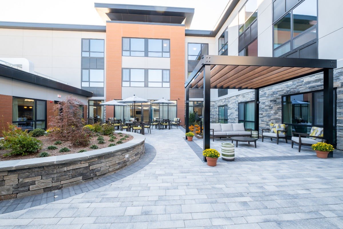 A modern building with a well-designed courtyard featuring outdoor seating and landscaping.