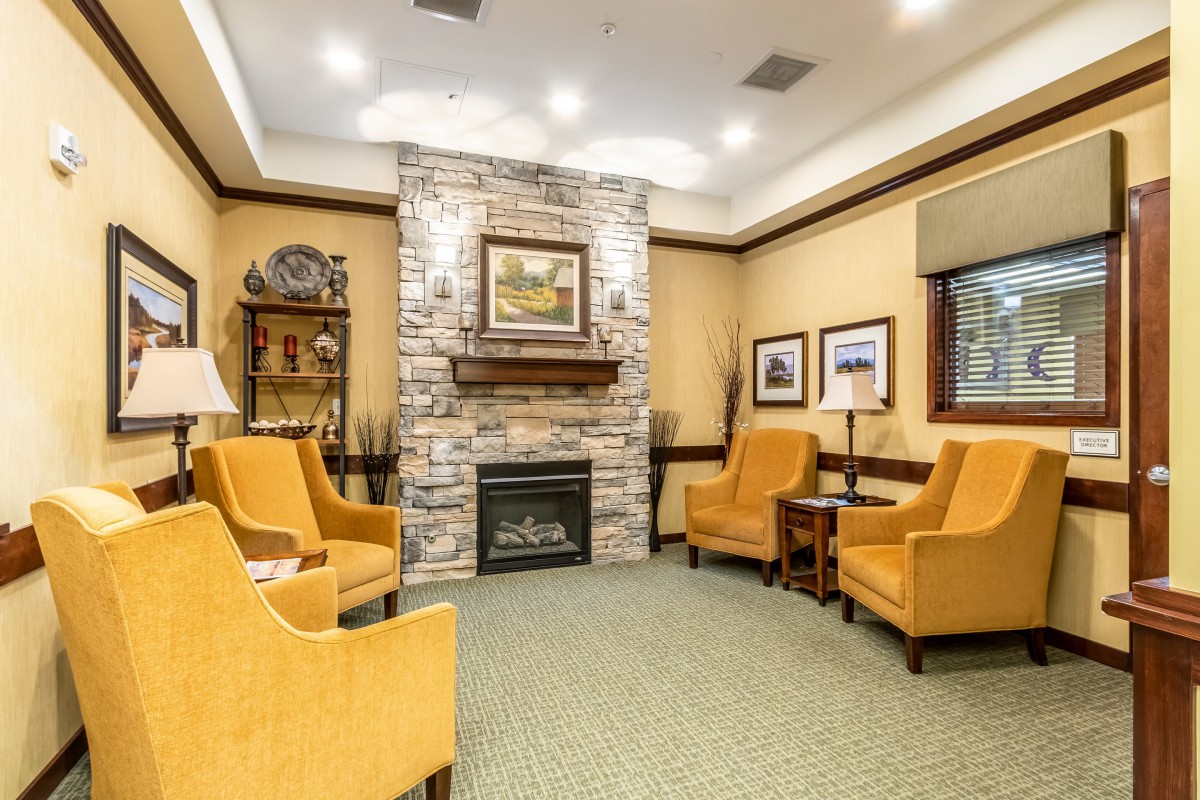 A cozy living room with a stone fireplace and comfortable seating.