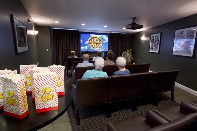 A cozy home theater setup with viewers enjoying a film, popcorn at hand.
