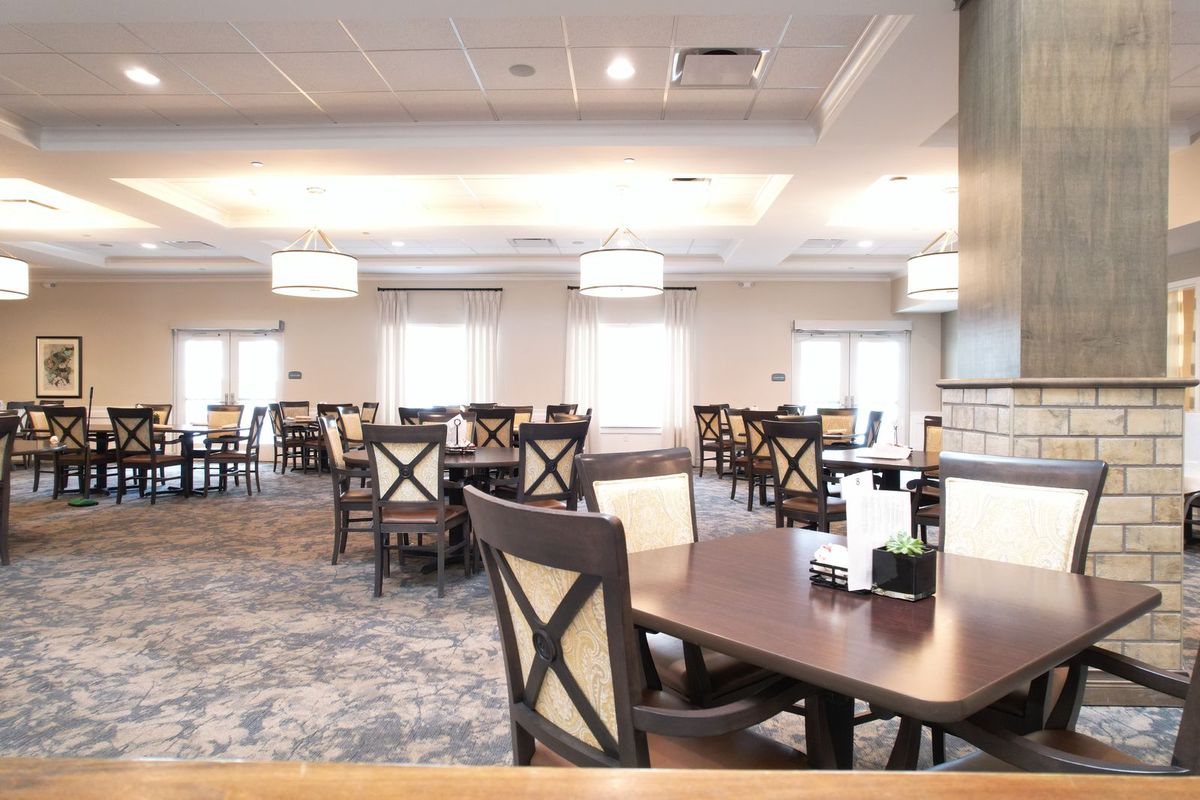An empty restaurant dining area with neatly arranged tables and chairs.