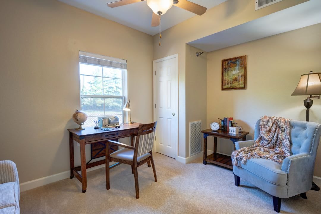 A cozy home office setup with a desk, chair, and window providing natural light.