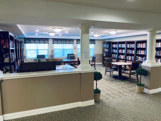 A quiet library with bookshelves and a reading area.