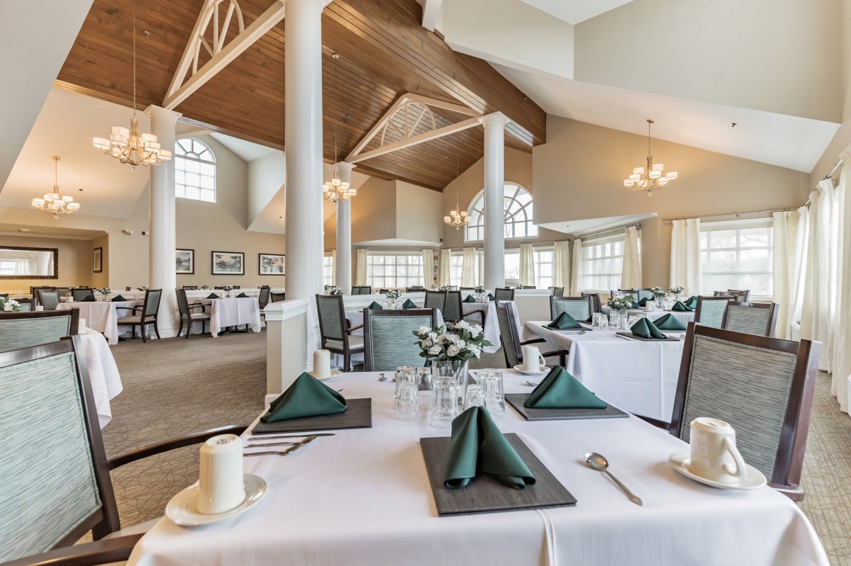 An elegant dining room with neatly arranged tables and chairs, featuring stylish decor.