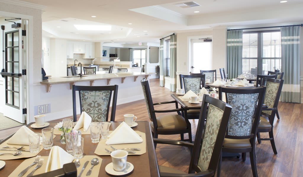 A modern dining area with neatly arranged tables and chairs, set up for a meal.