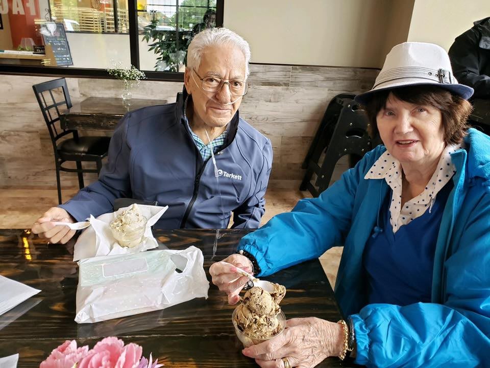An elderly couple enjoying a meal together at a cafe.