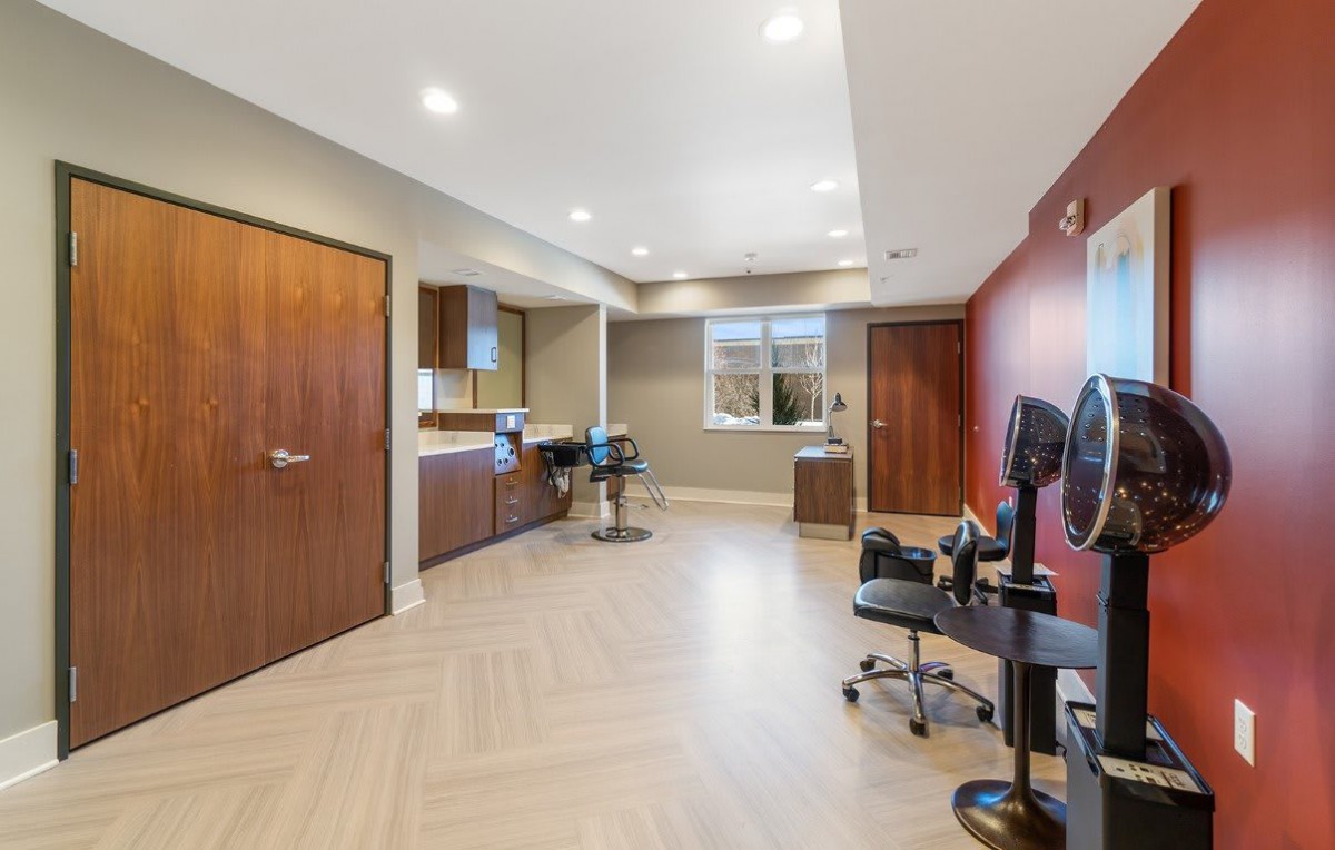 A modern office interior with desks, chairs, and computers.