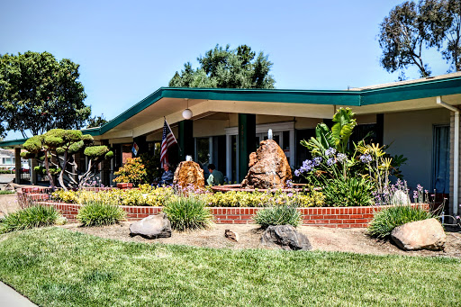 A vibrant garden landscape featuring a contemporary building with beautiful sculptures.