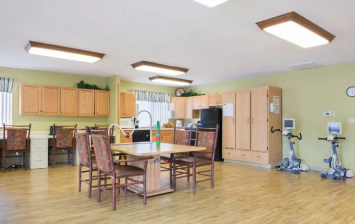 A spacious kitchen and dining area with wooden cabinets and a large table surrounded by chairs.