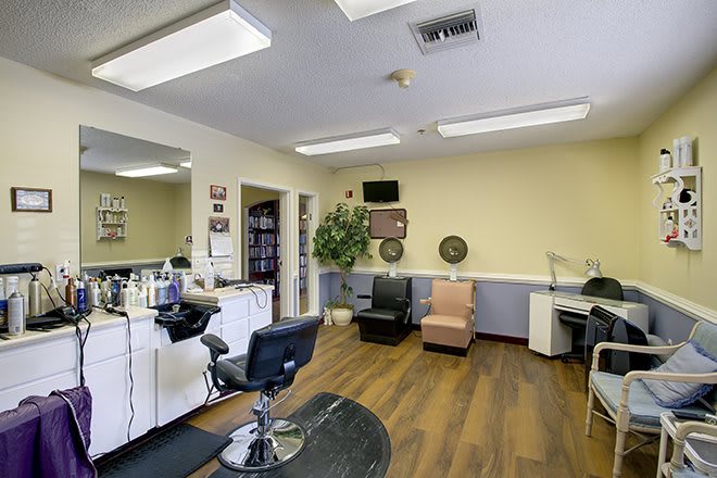A well-lit hair salon interior with styling stations and a waiting area.