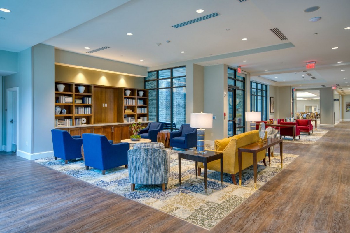A modern lobby with comfortable seating and bookshelves.