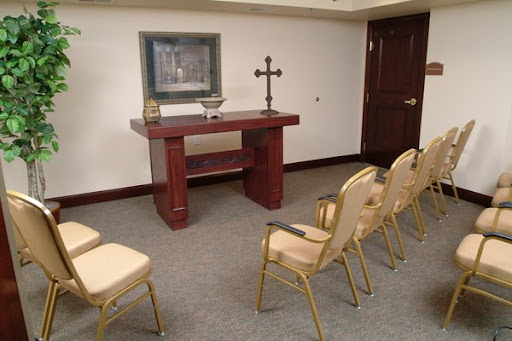 A serene chapel setting with an altar, a cross, and chairs for congregation.