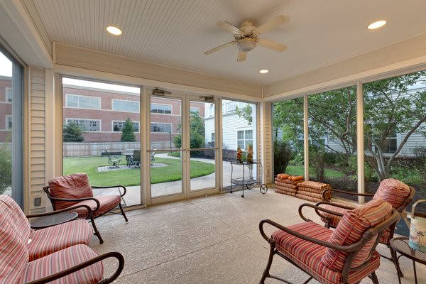 A cozy sunroom with comfortable seating and glass doors offering a view of the garden.