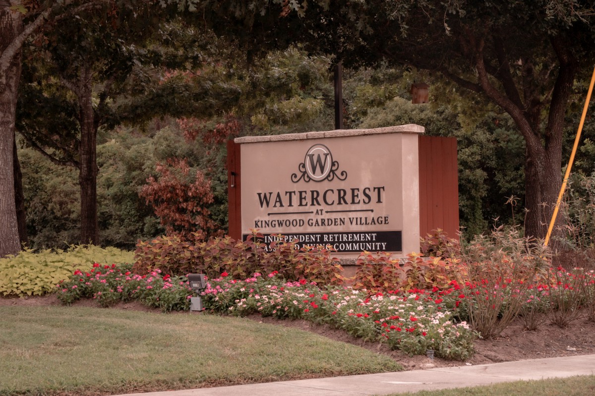 A welcoming entrance sign for Watercrest residential community, surrounded by vibrant landscaping and flowers.