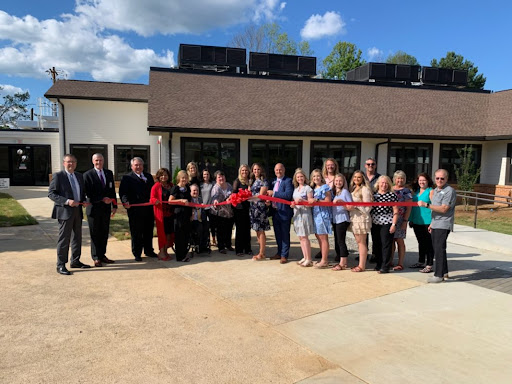 A group of people gathered for a ribbon-cutting ceremony to celebrate the opening of a new building.