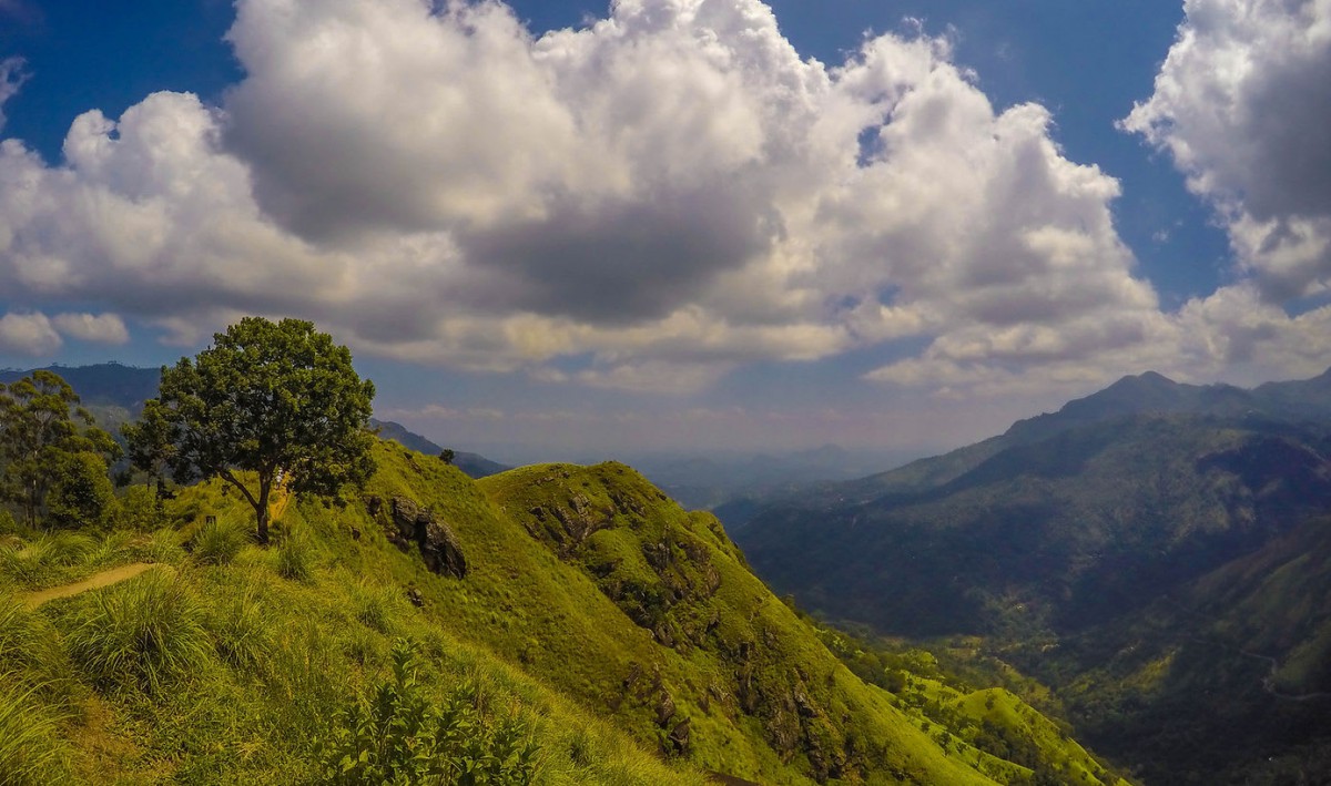 A picturesque view of lush green mountains under a partly cloudy sky.