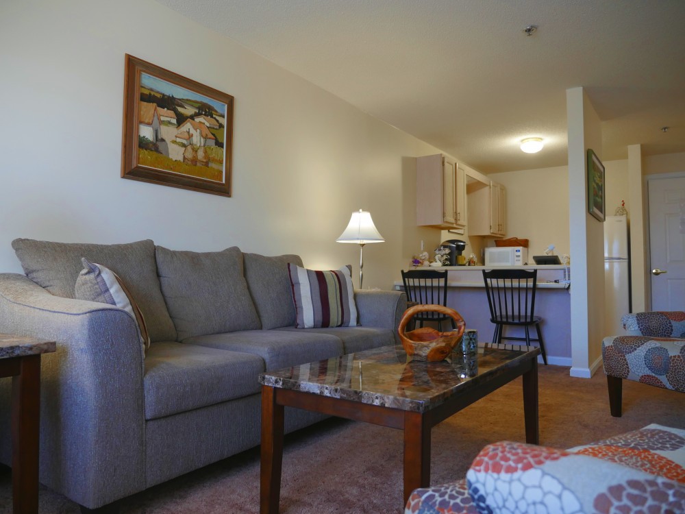 A cozy living room featuring a comfortable sofa, coffee table, and warm lighting.