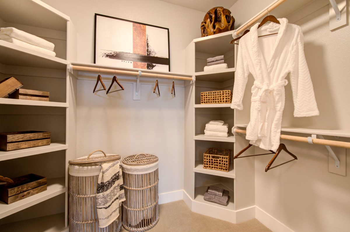 A well-organized closet with shelves, hangers, and storage baskets.