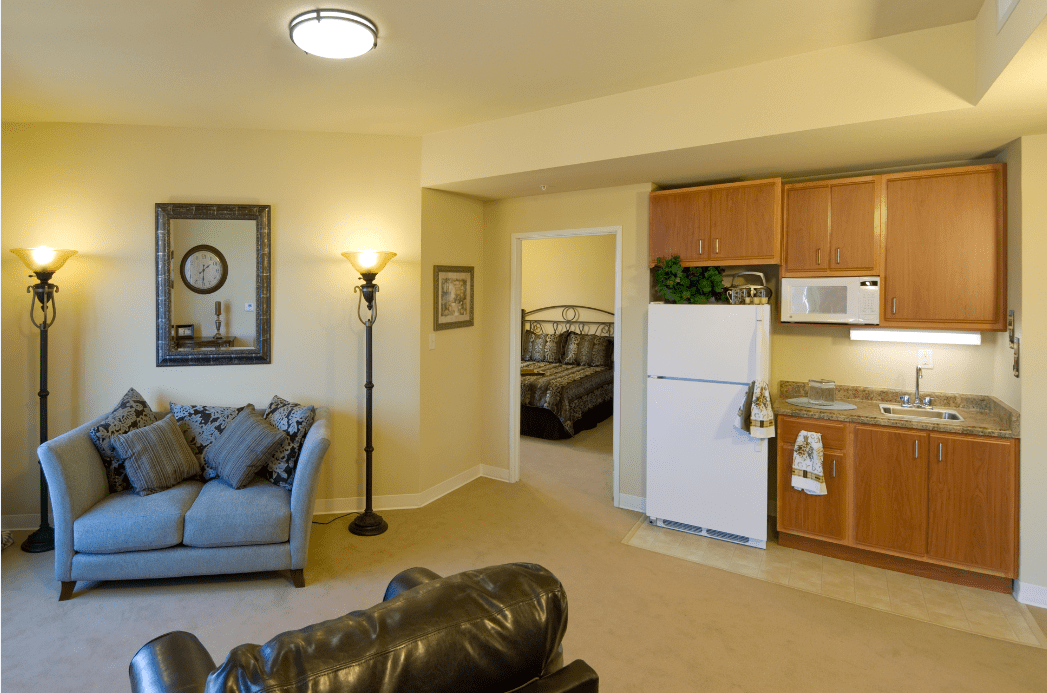 A cozy living space with a connected kitchen and a glimpse into the bedroom.