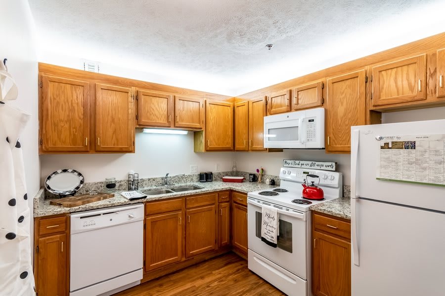 A cozy kitchen with wooden cabinets and modern appliances.