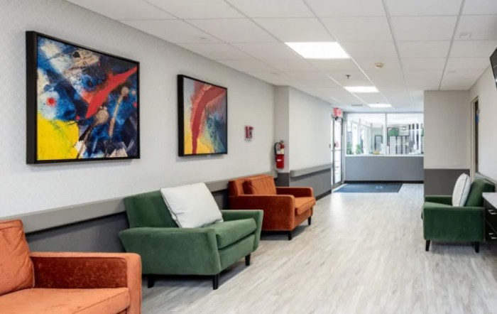 A modern lobby area with colorful chairs and abstract artwork on the walls.