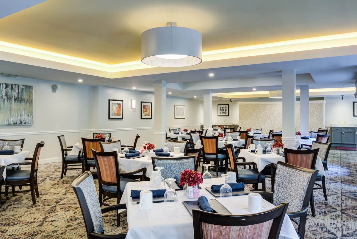 An elegantly set dining room in a restaurant, featuring neatly arranged tables and chairs with stylish decor.