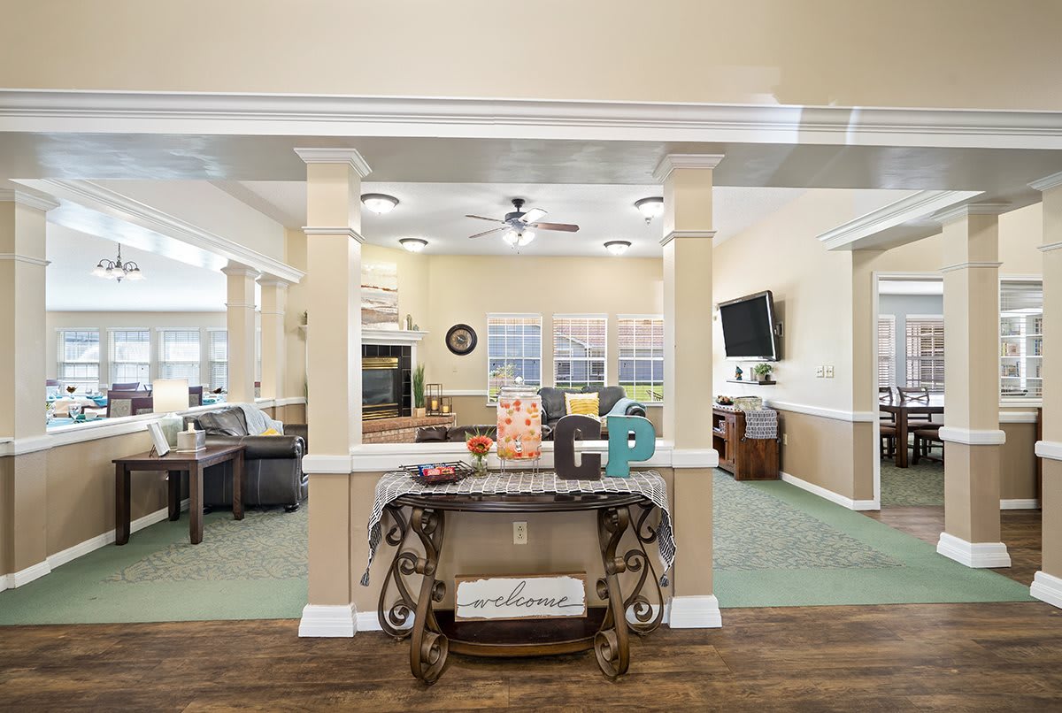 A spacious living room with elegant decor and an open layout featuring columns and wood flooring.