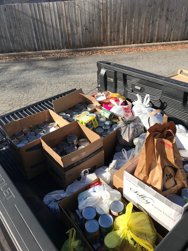 A collection of items for donation organized in the back of a pickup truck.