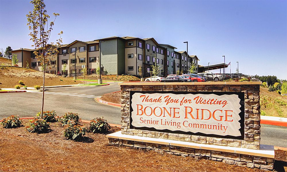 Entrance sign for Boone Ridge Senior Living Community with residential buildings in the background.