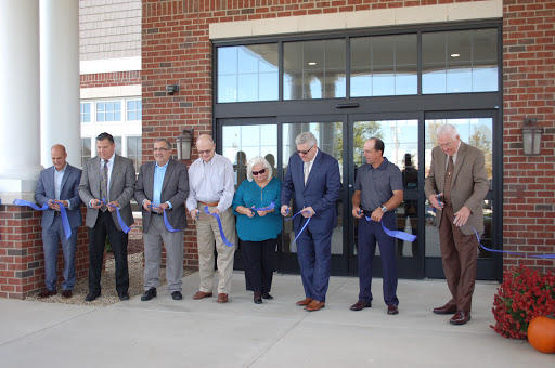 Community leaders gather for a ribbon-cutting ceremony to celebrate the grand opening of a new facility.
