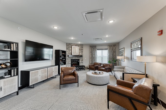 A modern living room featuring comfortable seating, a large television, and stylish decor.