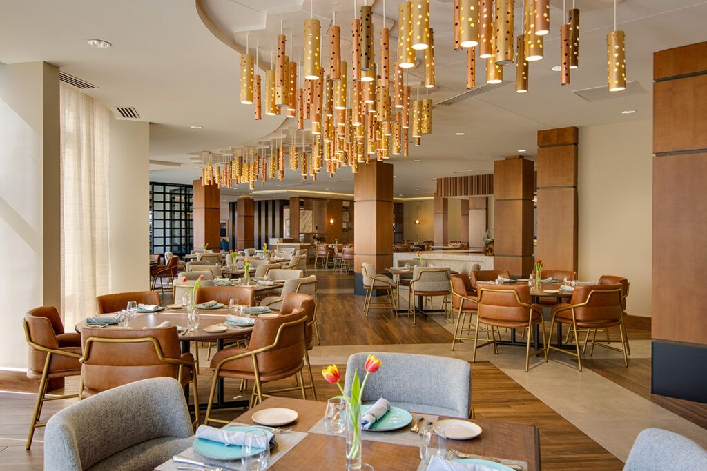 A modern and elegant restaurant interior with stylish chandeliers and well-arranged table settings.