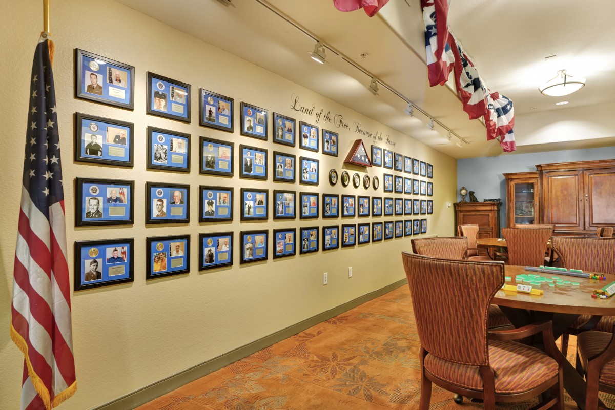An interior view of a cafe with a wall adorned with framed photos and patriotic decorations.