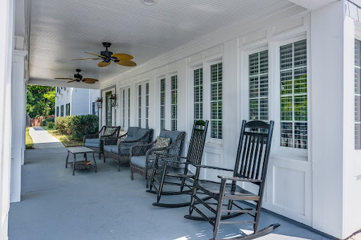 A serene porch featuring rocking chairs and ceiling fans, perfect for relaxation.