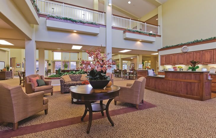 A spacious lobby with comfortable seating and a central floral arrangement.