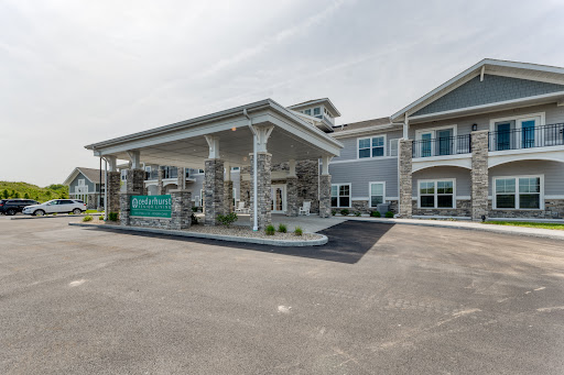 View of a modern hotel entrance with a covered portico and landscaped surroundings.