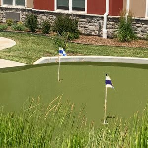 A small outdoor putting green with flags marking holes.