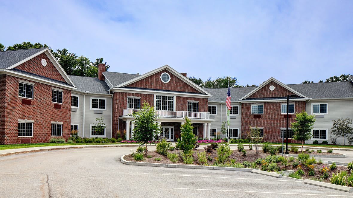 A two-story residential building with a landscaped entrance and driveway.