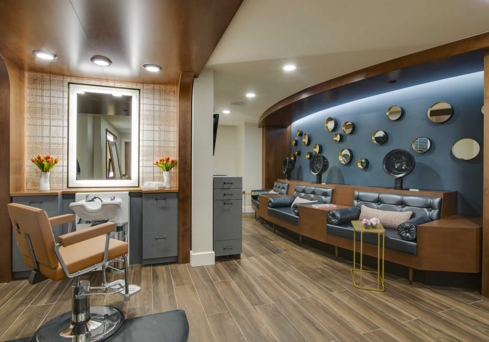 A modern salon interior featuring comfortable seating and decorative elements on the walls.