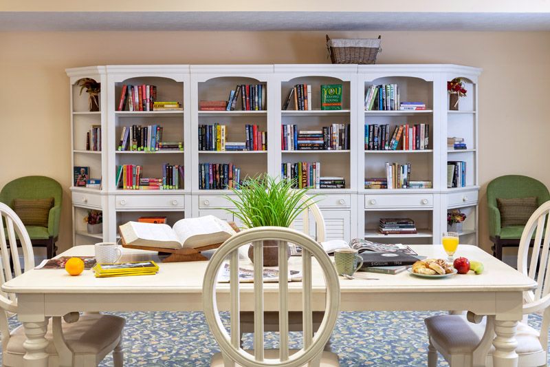 A cozy interior with a large bookshelf and a table set up for reading.