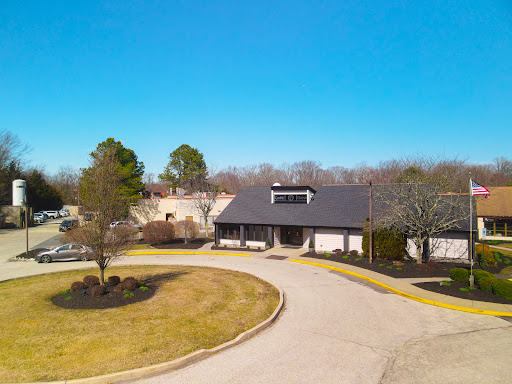 A photo capturing a modern building surrounded by a well-maintained landscape and clear blue skies.