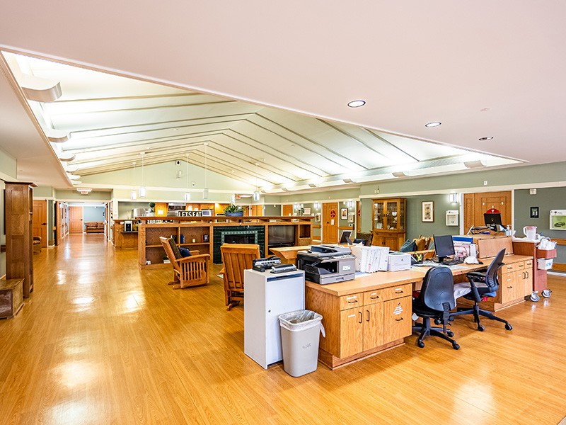 An open office space with several desks and computers on a wooden floor.