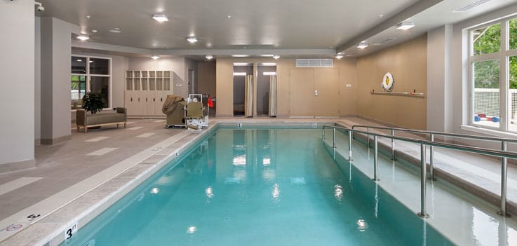 A serene indoor swimming pool with lanes and seating area.