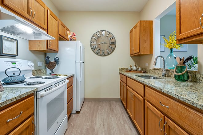 A modern kitchen with wooden cabinets and standard appliances.