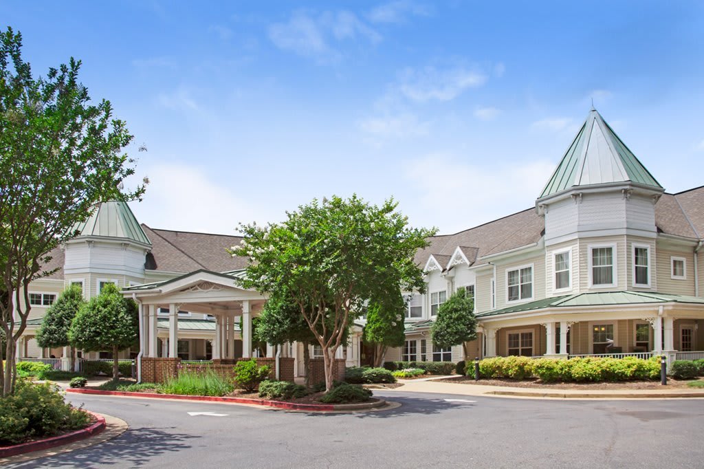 A charming residential building with a well-maintained landscape under a clear blue sky.