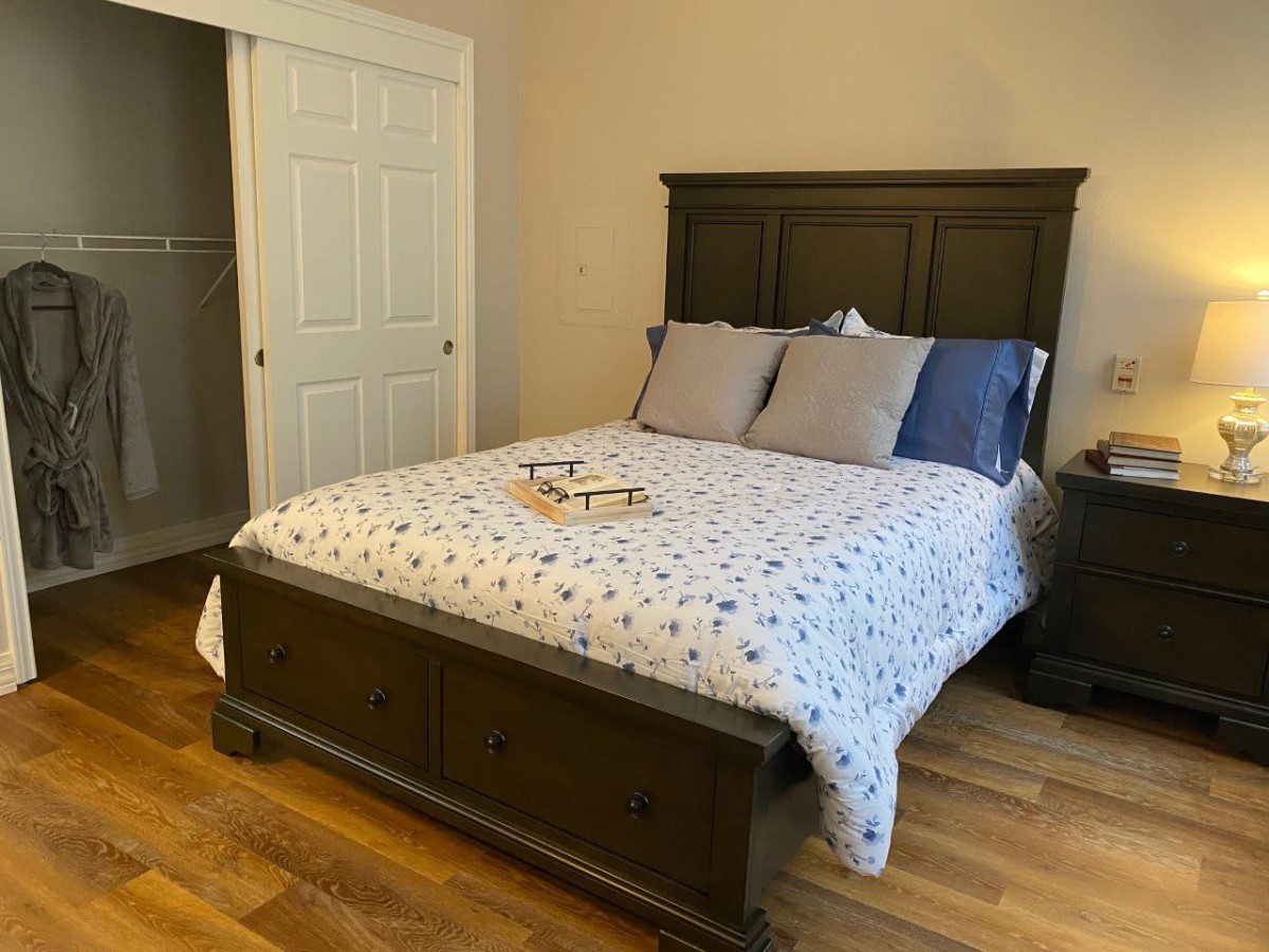 A cozy bedroom featuring a wooden bed with patterned bedding and pillows.