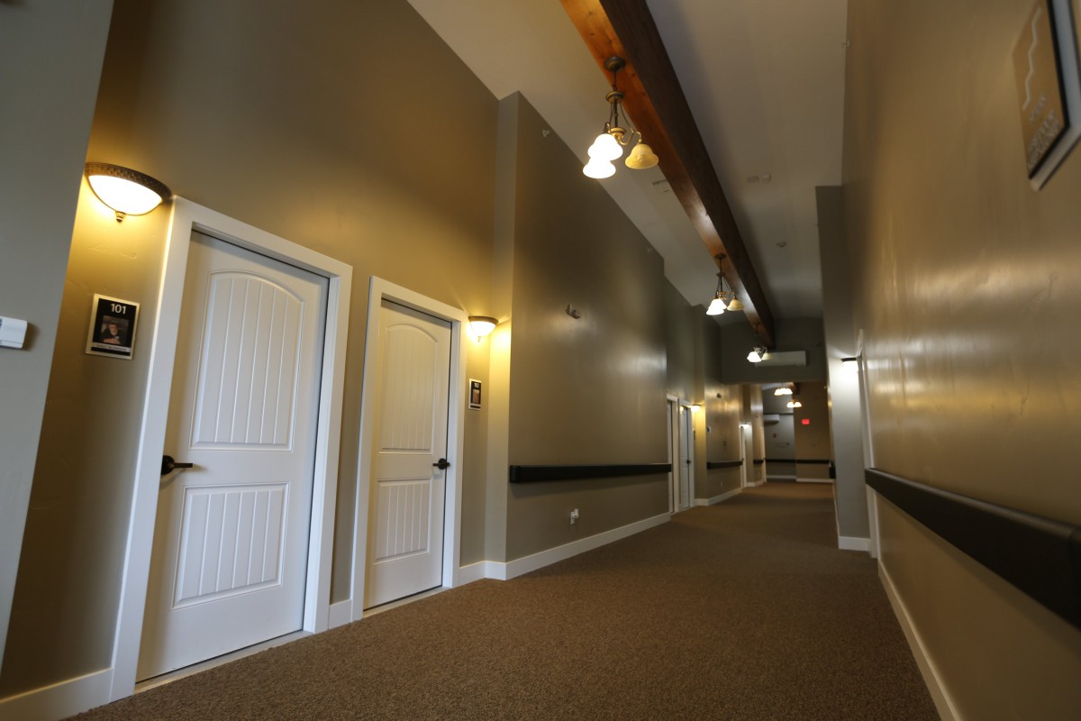 A long corridor with multiple doors and overhead lighting.